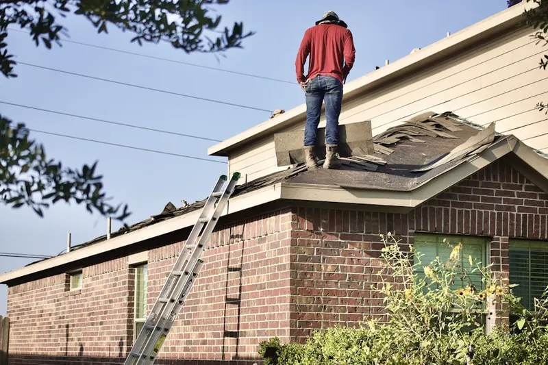 Professional roofer working on a residential roof in Watts
